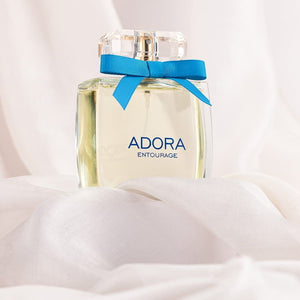Sticlă parfum „ADORA Entourage” femei, cu panglică albastră și capac transparent, accentuat pe textură fină.