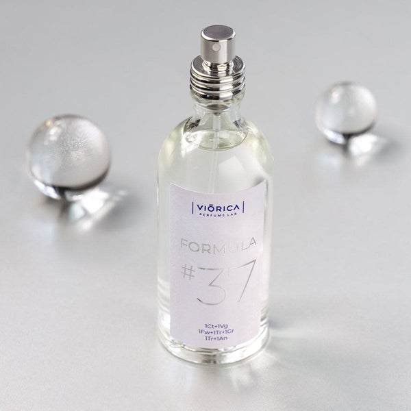 Sticluță Apă de Parfum FORMULA #37 femei, capac argintiu, lichid transparent, detaliu etichetă clar.