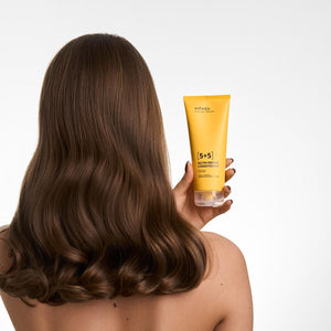 Femeie ținând balsam Viorica Nutri-Reparator 5+5, tub galben, păr castaniu lucios și mătăsos.