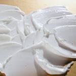 Textură cremoasă albă a cremei de corp supernutritive „5 Uleiuri”, detaliu mătăsos și hidratant.