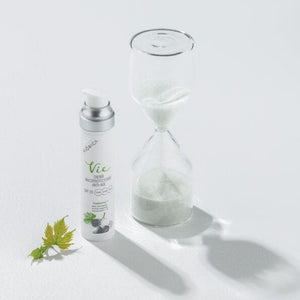 Cremă anti-age cu SPF20 Viorica Vie lângă clepsidră, design alb și argintiu.