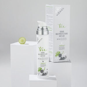Sticlă cremă anti-age SPF20 Viorica Vie, albă cu pompiță argintie și ambalaj, detaliu strugure verde.