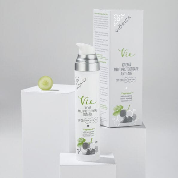 Sticlă cremă anti-age SPF20 Viorica Vie, albă cu pompiță argintie și ambalaj, detaliu strugure verde.