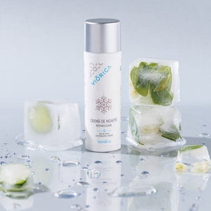 Cremă de noapte reparatoare Nordica, ambalaj alb, capac argintiu, înconjurat de cuburi de gheață cu plante.