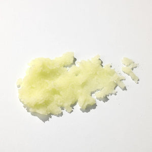 Exfoliant corp textura granulată, nuanță galben deschis, ingrediente naturale, detaliu sare fină.