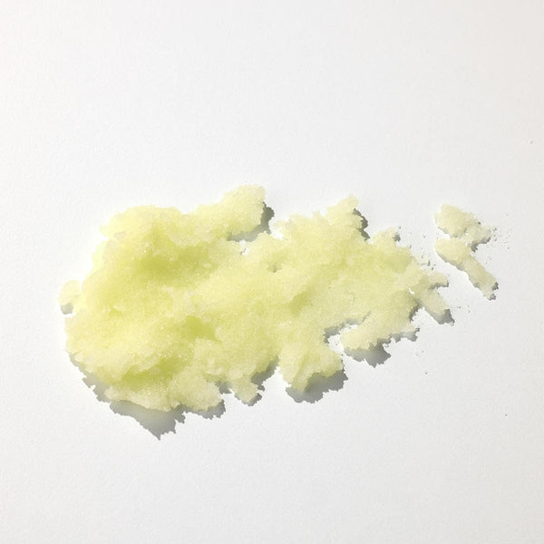 Exfoliant corp textura granulată, nuanță galben deschis, ingrediente naturale, detaliu sare fină.