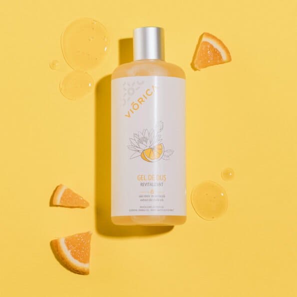 Sticlă gel de duș revitalizant Viorica, capac argintiu, decorată cu desene de citrice pe fundal galben.