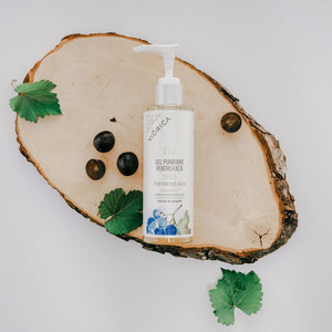 Gel purifiant pentru față Viorica Vie pe suport lemn, decorat cu frunze și fructe, flacon pompiță alb.