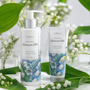 Lapte de corp Elixir Floral cu lăcrămioare albe, etichetă florală, capac alb, design elegant.