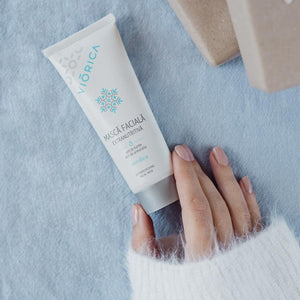 Cremă albă pentru îngrijirea tenului uscat cu design Nordic, capac argintiu și mânecă de pulover în imagine.