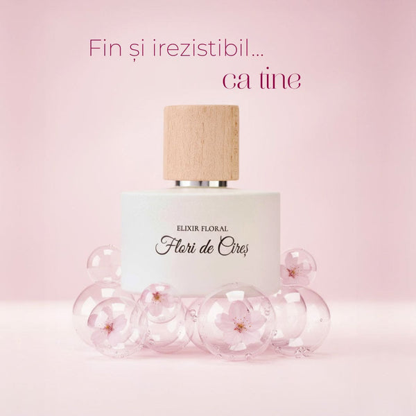 Parfum Elixir Floral Flori de Cireș, sticlă albă, capac lemn natur, decorat cu bule și flori de cireș în fundal roz.