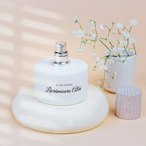 Parfum Elixir Floral Lăcrămioara Albă, sticlă albă cu capac argintiu, decor floral.