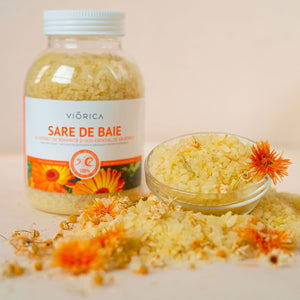 Sare de baie Viorica, nuanță galbenă, cu mușețel și galbenele, în borcan transparent și bol mic decorativ.