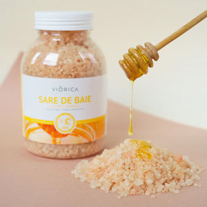 Sare de baie cu miere și propolis Viorica, granule roz, capac alb, etichetă alb-galbenă, miere picurată.