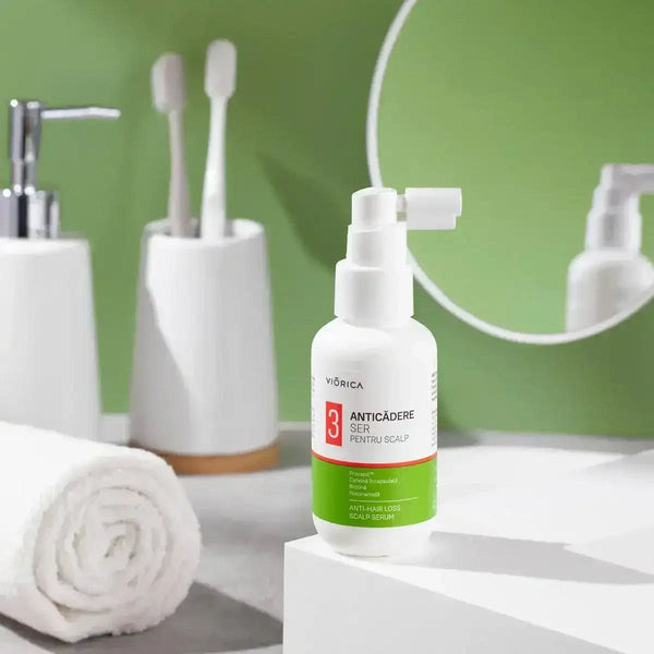 Ser anticădere scalp Viorica, sticlă albă cu etichetă verde, detaliu pulverizator, fundal baie modernă.