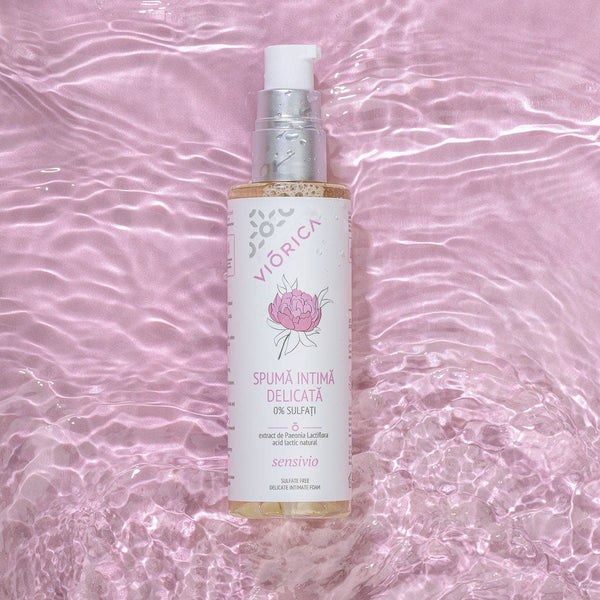 Spumă intimă Viorica Sensivio cu extract de Paeonia, ambalaj alb și argintiu, pe fundal roz satinat.